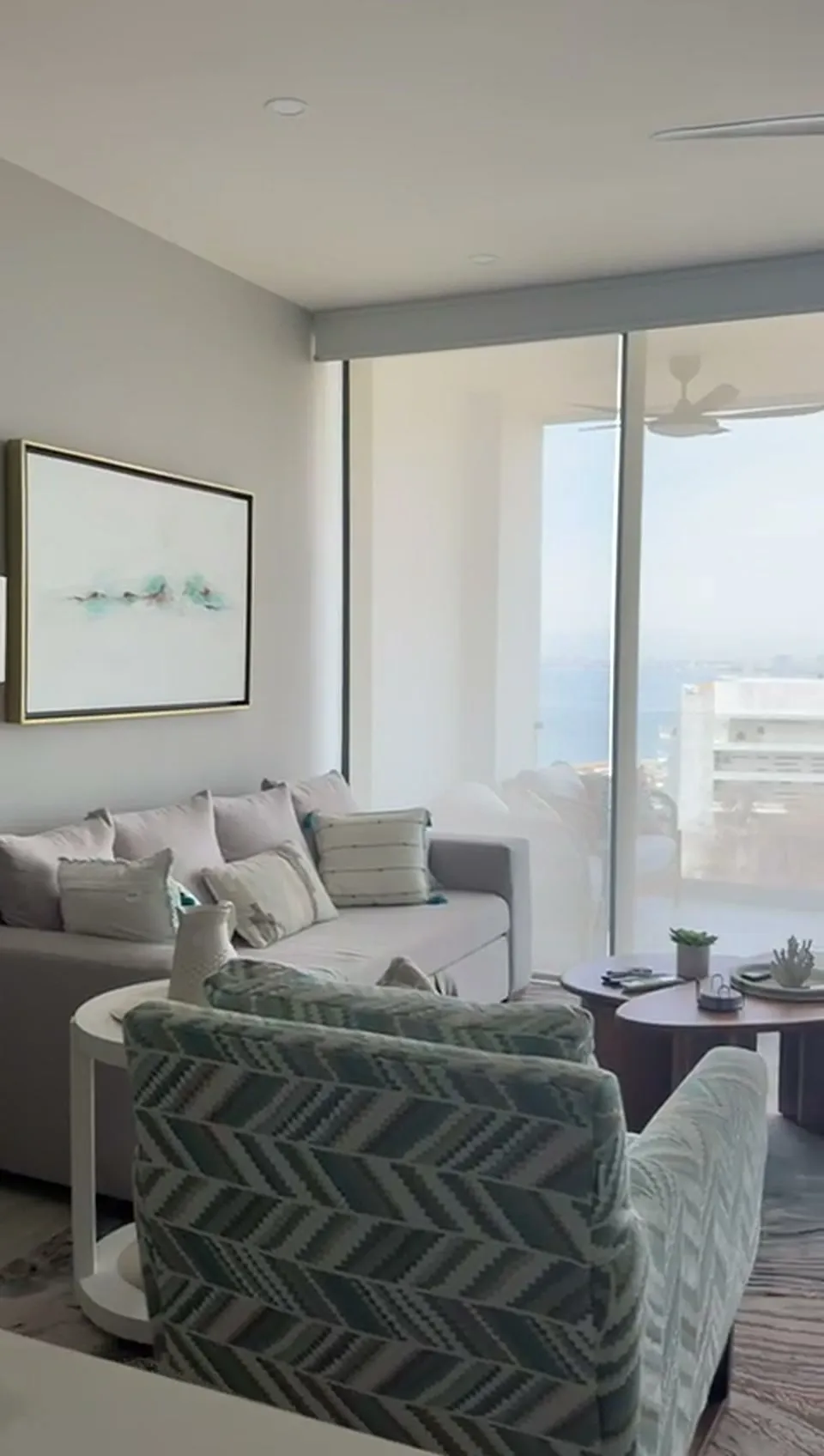 Sala con ventanal de piso a techo y vista a la ciudad